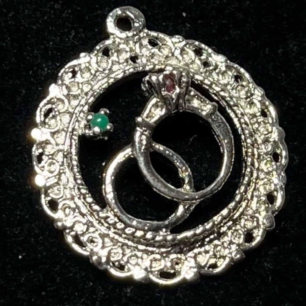 Vintage sterling silver wedding rings pendant. Features a green & red gemstone